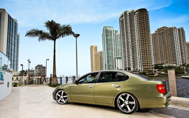 green sedan in city by water