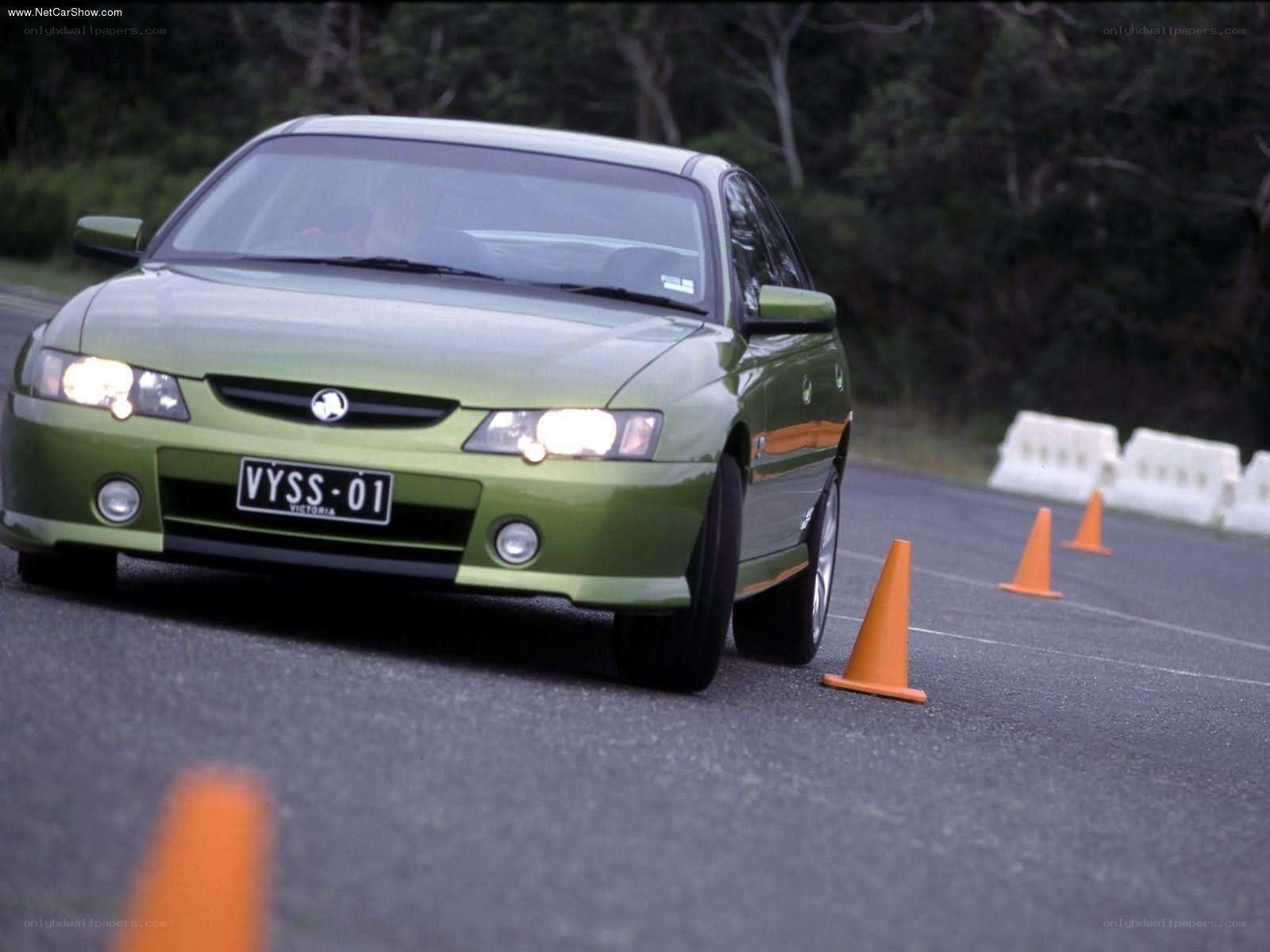 green sedan navigating cones