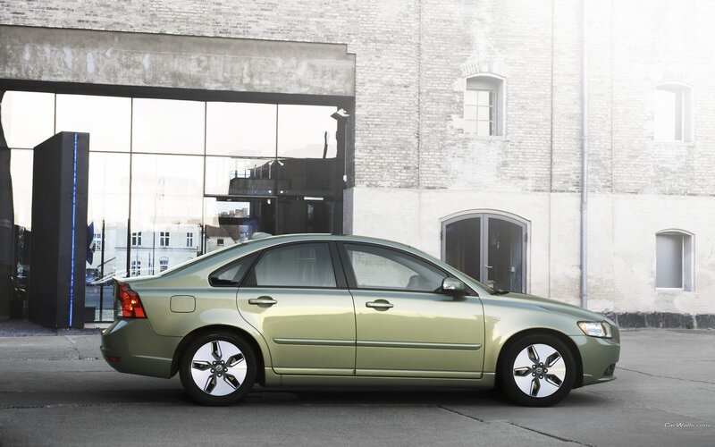 green sedan parked in urban setting