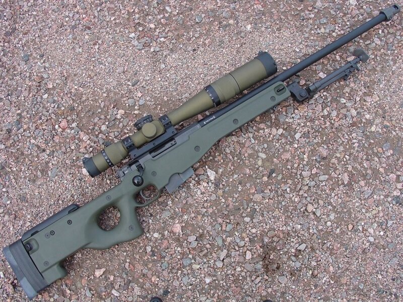 green sniper rifle on gravel