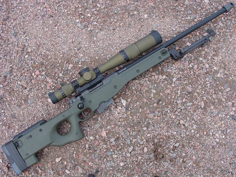 green sniper rifle on gravel