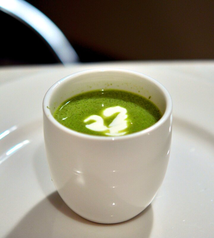 Green soup with cream swirl