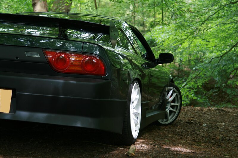 Green sports car in forest