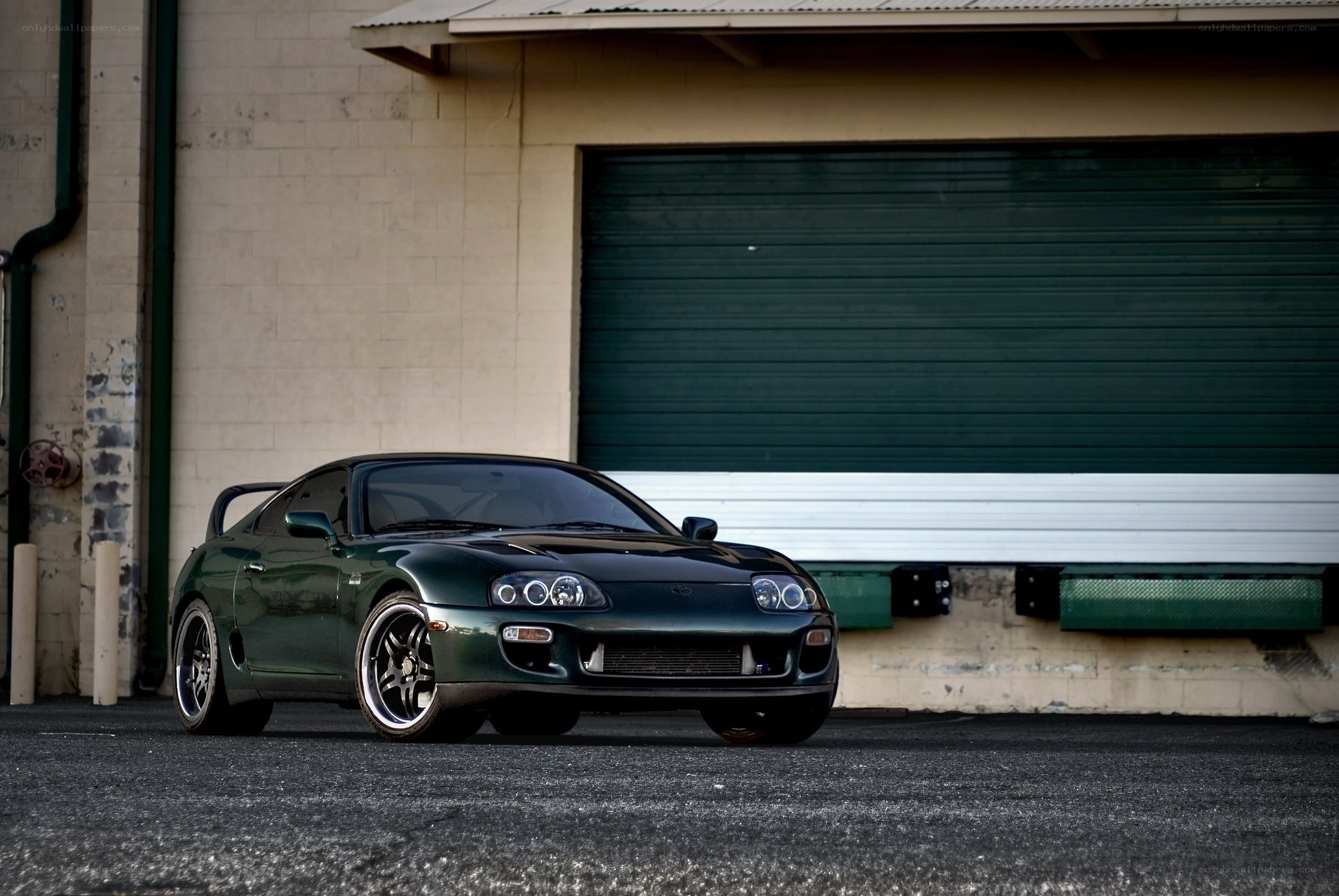 Green sports car in front of garage