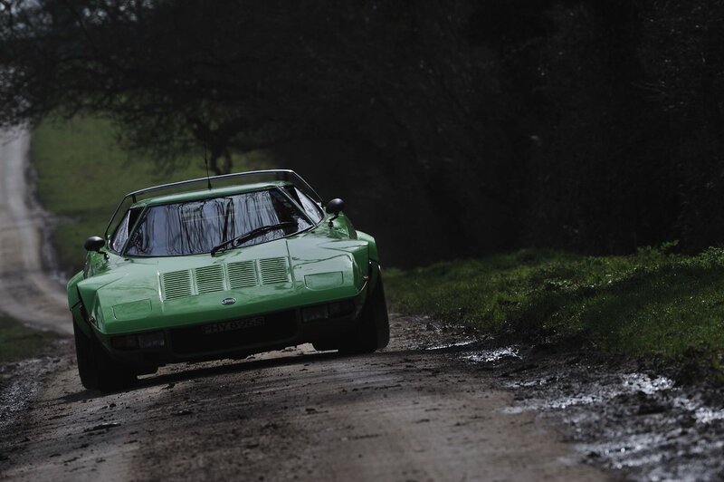 Green sports car on a muddy road
