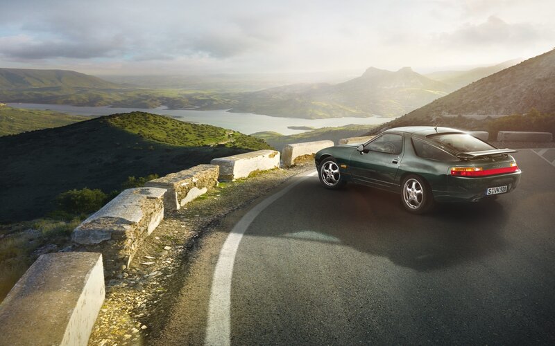 Green sports car on mountain road