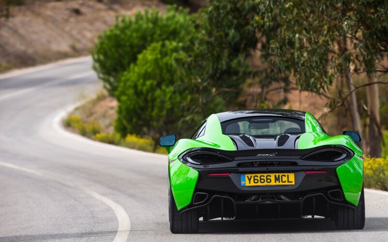 green sports car on winding road