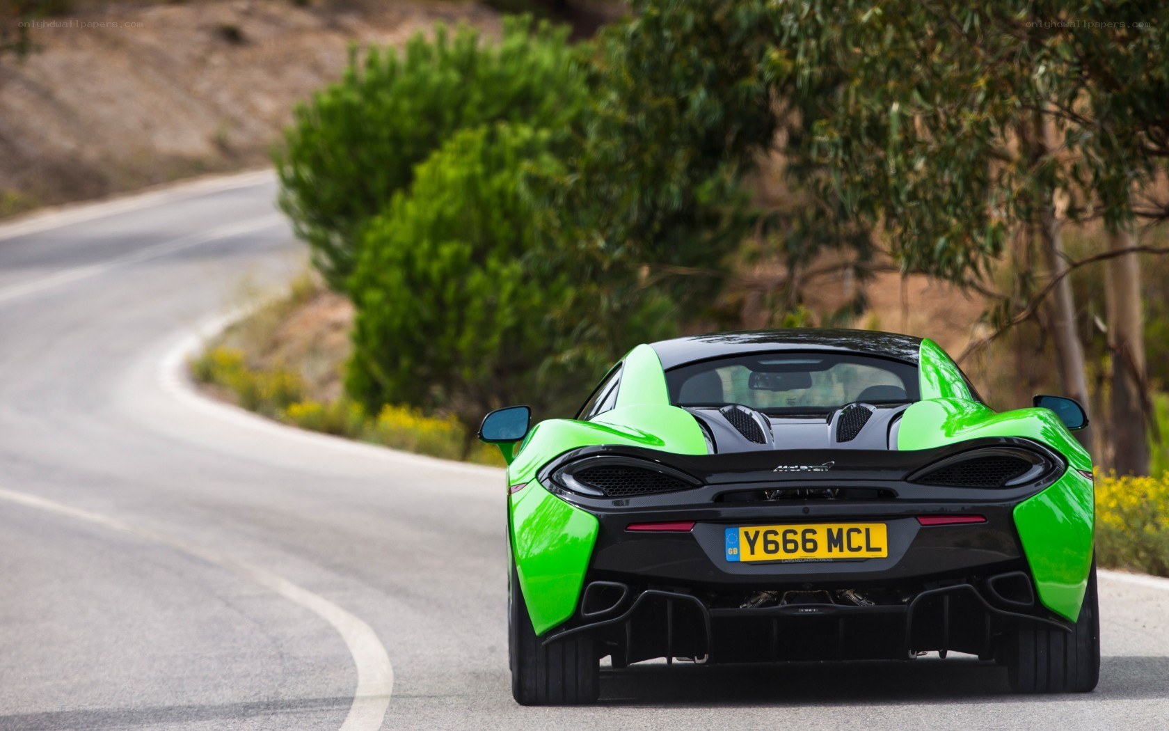 green sports car on winding road