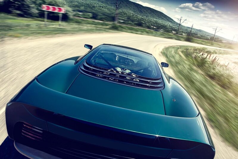 green sports car on winding road