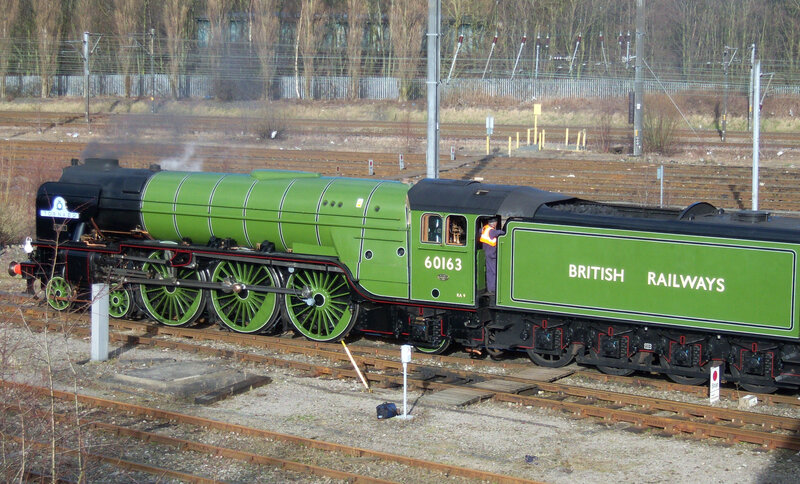 Green steam locomotive on tracks