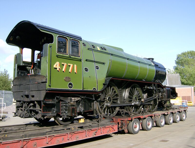Green steam locomotive on transport