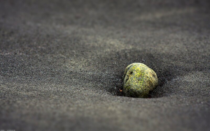 green stone in black sand