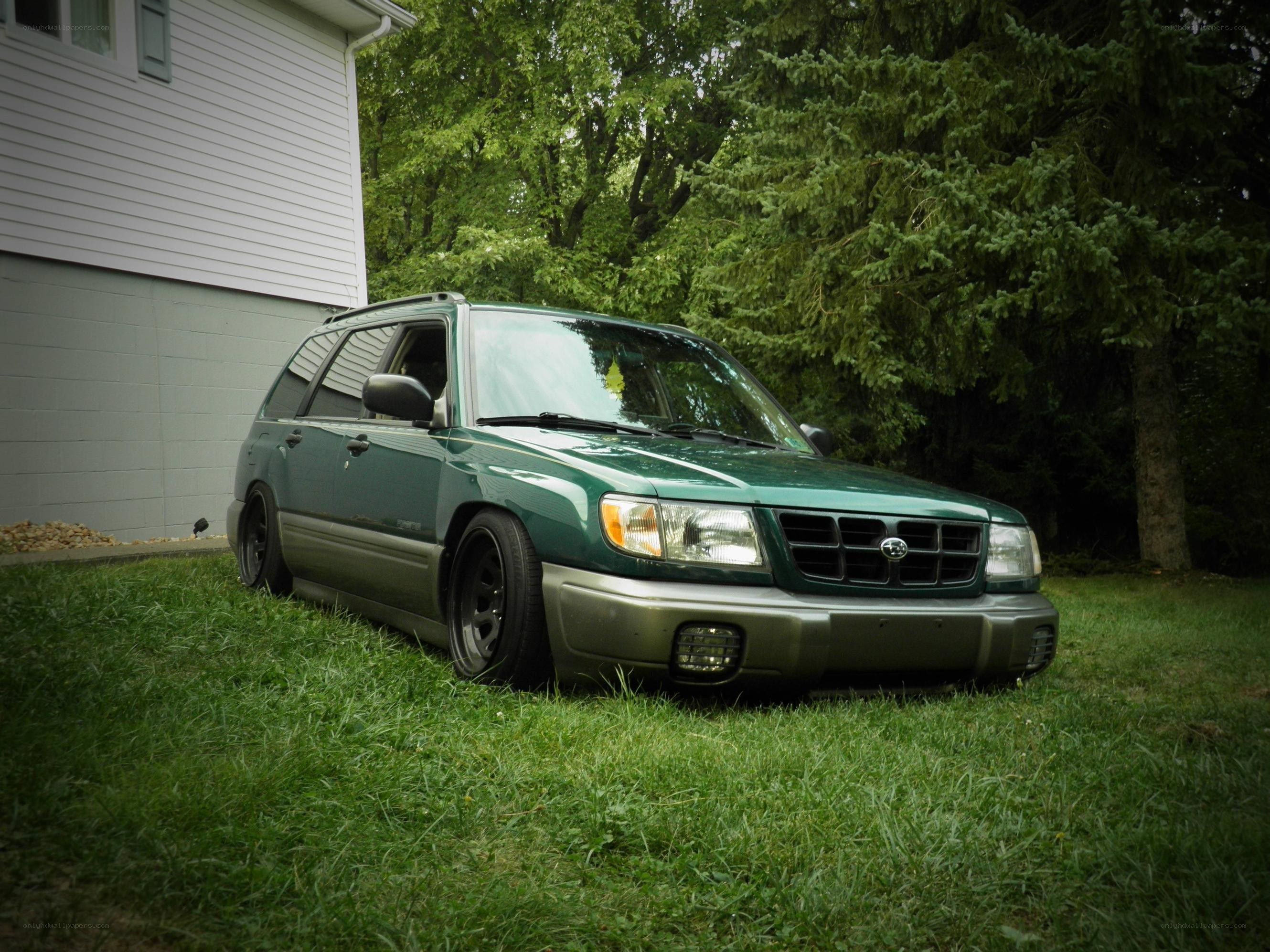 green subaru forester on grass