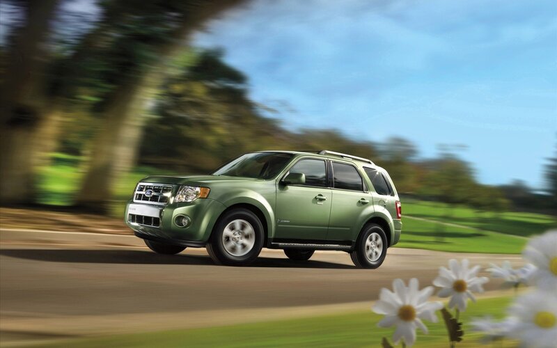 Green SUV driving on a road