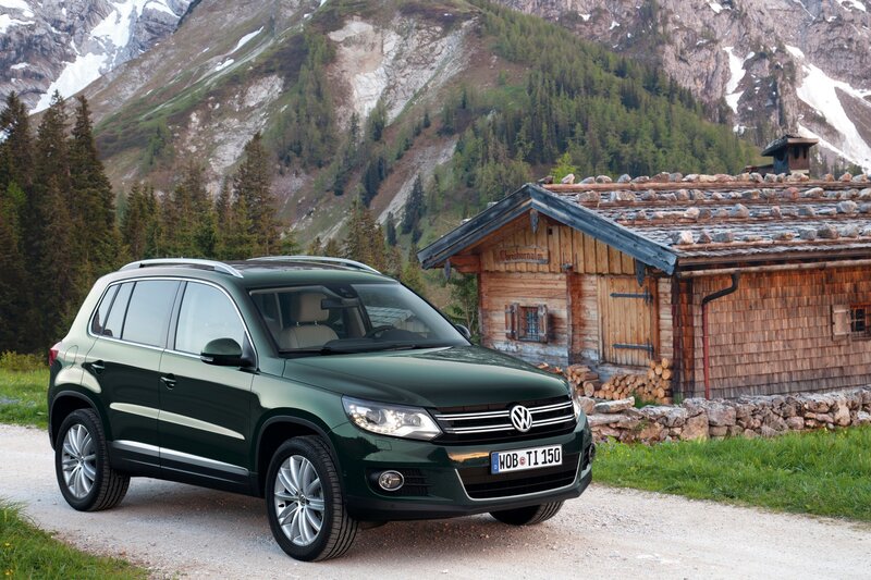 Green SUV in mountain village