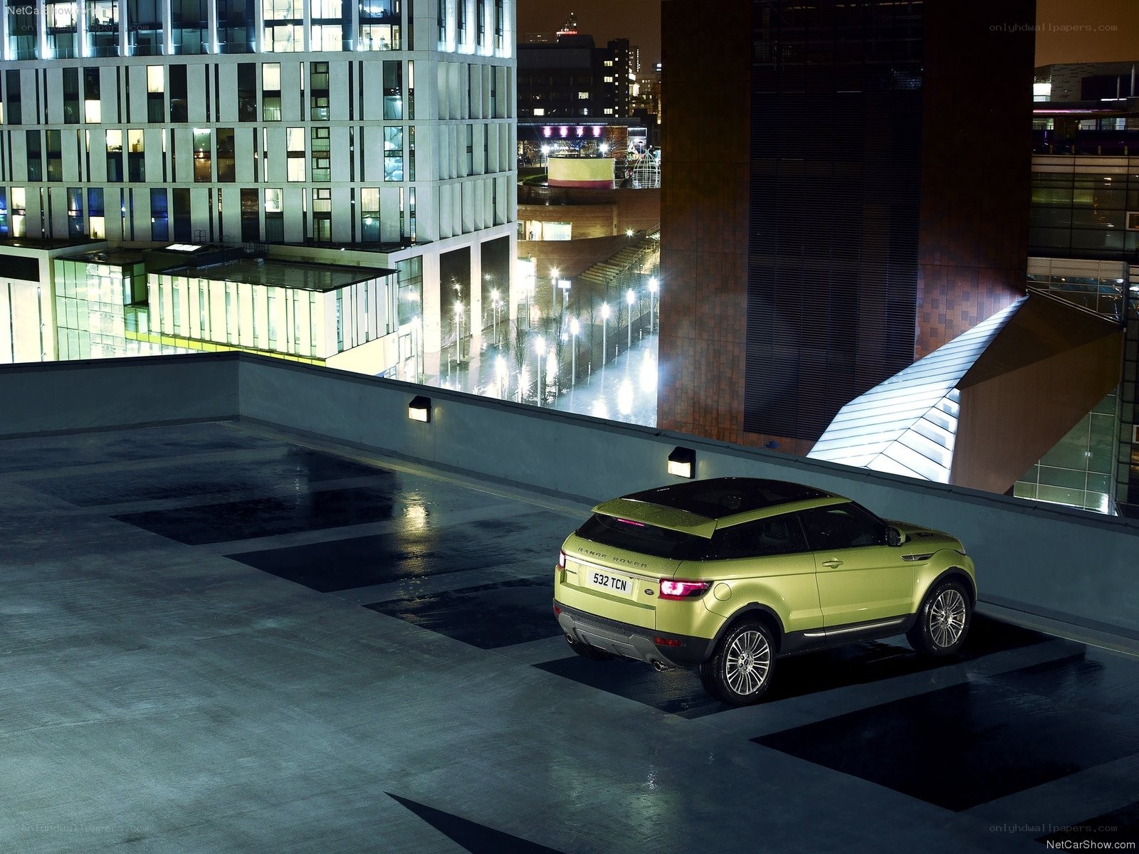 Green SUV on rooftop at night