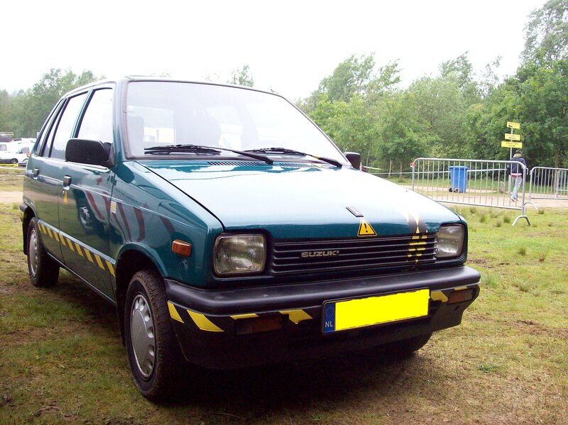 green suzuki car on grass