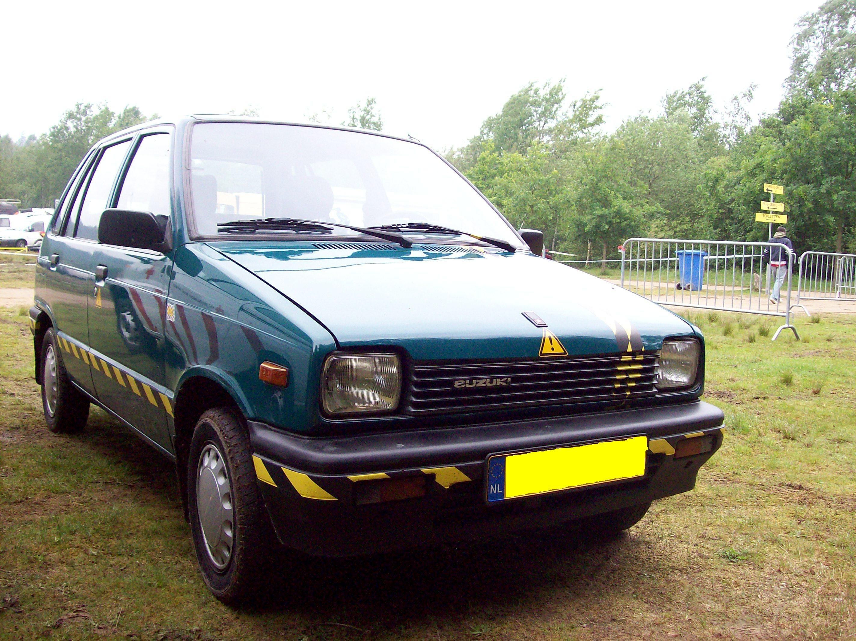 green suzuki car on grass