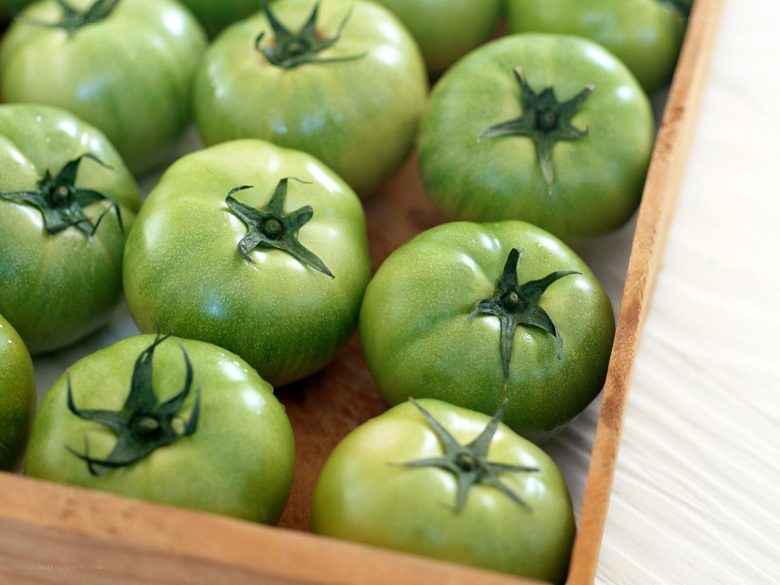green tomatoes in a wooden crate