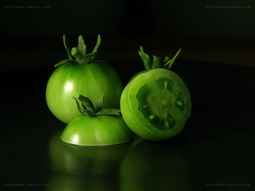 Green tomatoes on dark surface