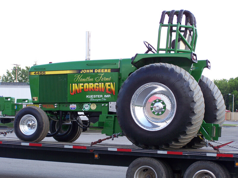 green tractor on flatbed trailer