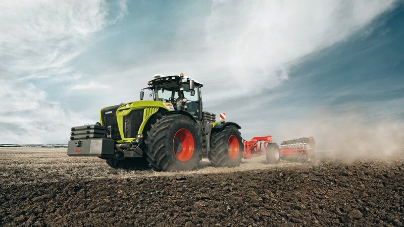 Green Tractor Plowing Field — Dramatic