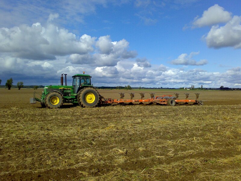 Green Tractor Plowing Field — Serene