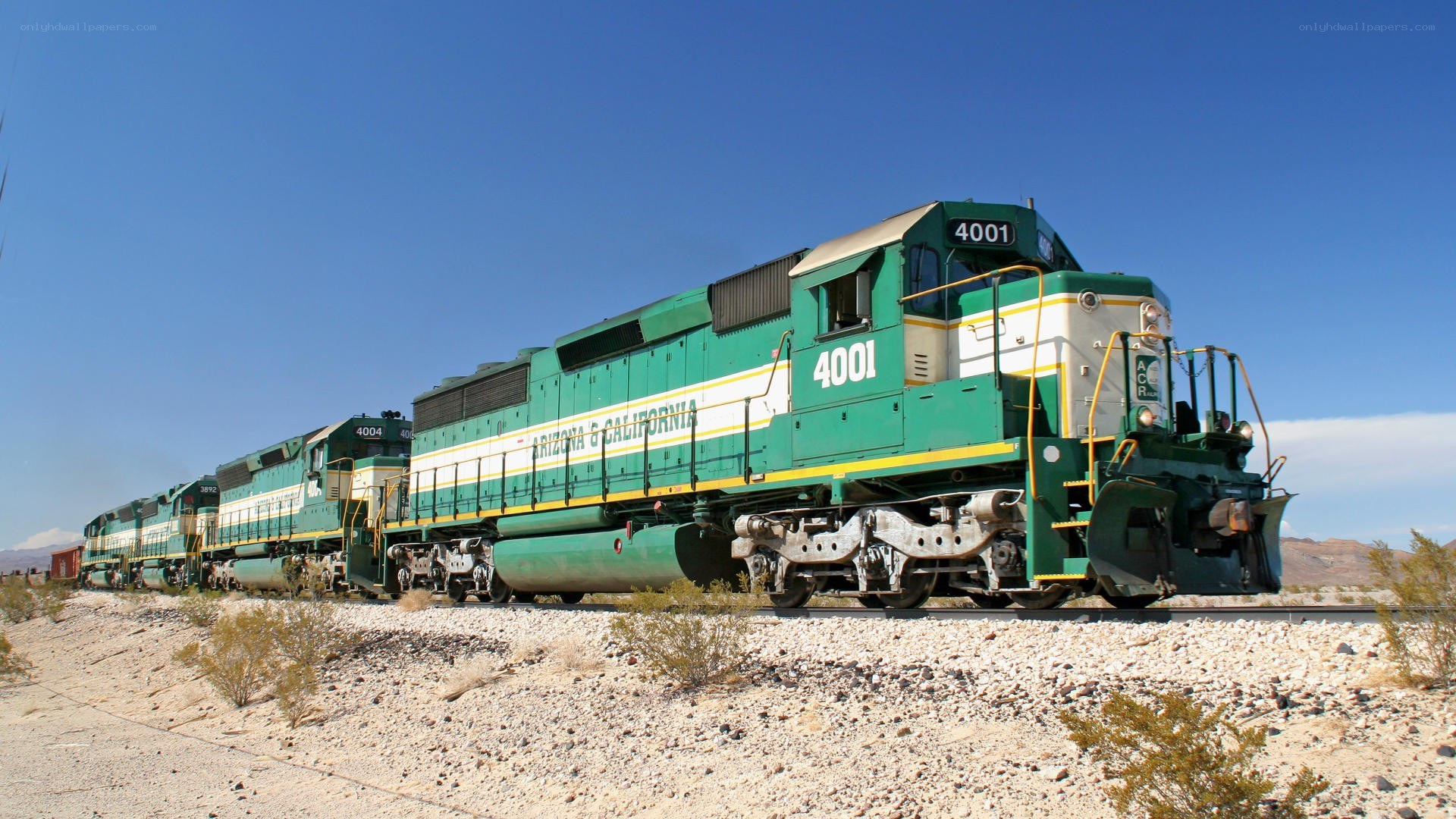 Green train in desert landscape