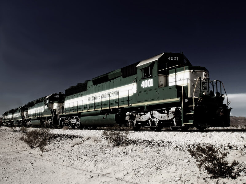 Green train in desert landscape