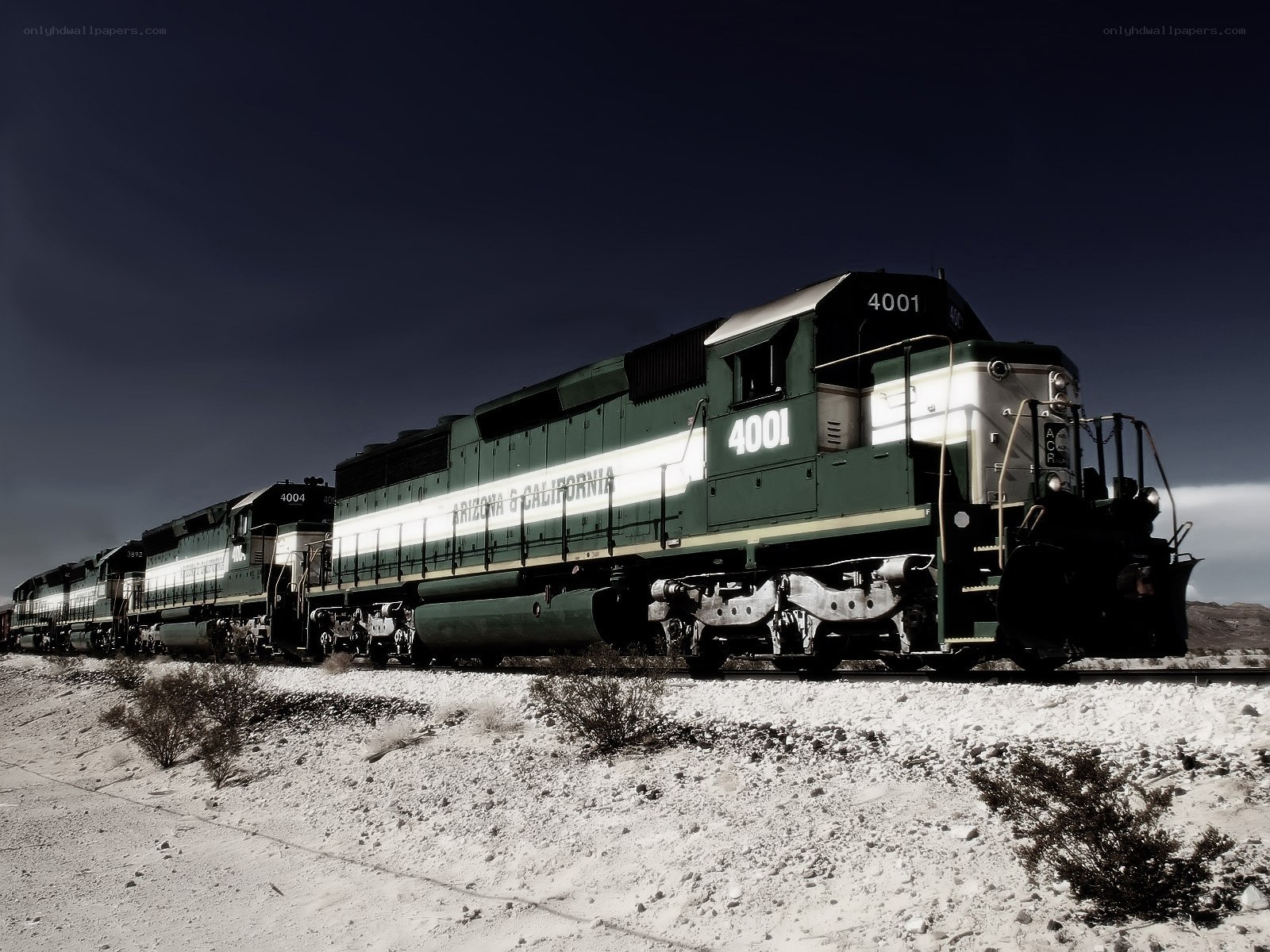 Green train in desert landscape