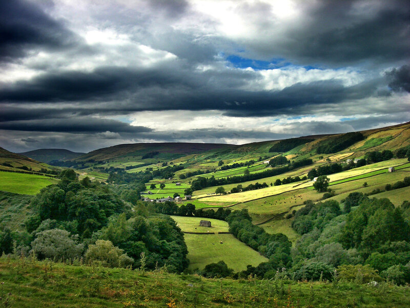 Green valley under stormy sky