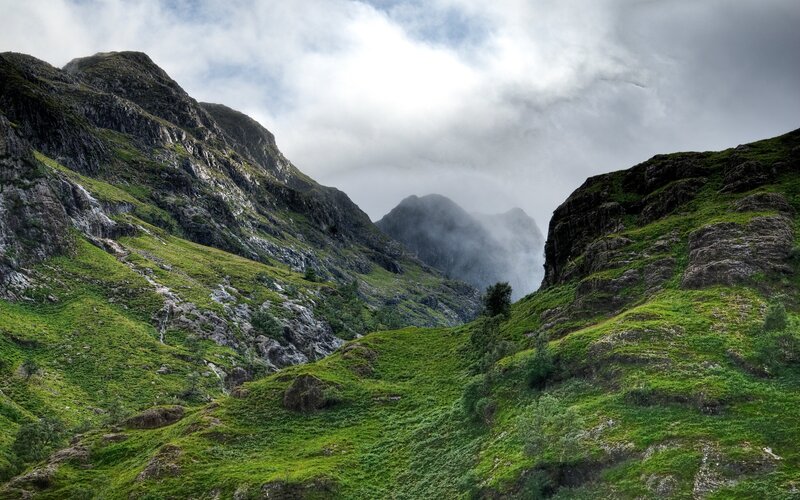 Green valley with misty mountains