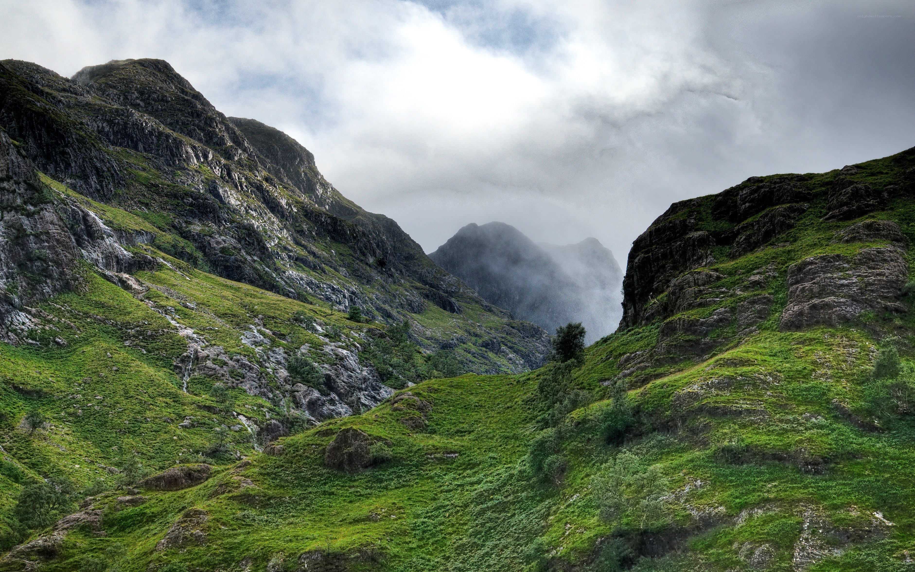 Green valley with misty mountains