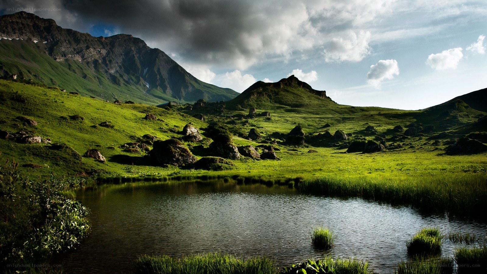 Green valley with mountain lake