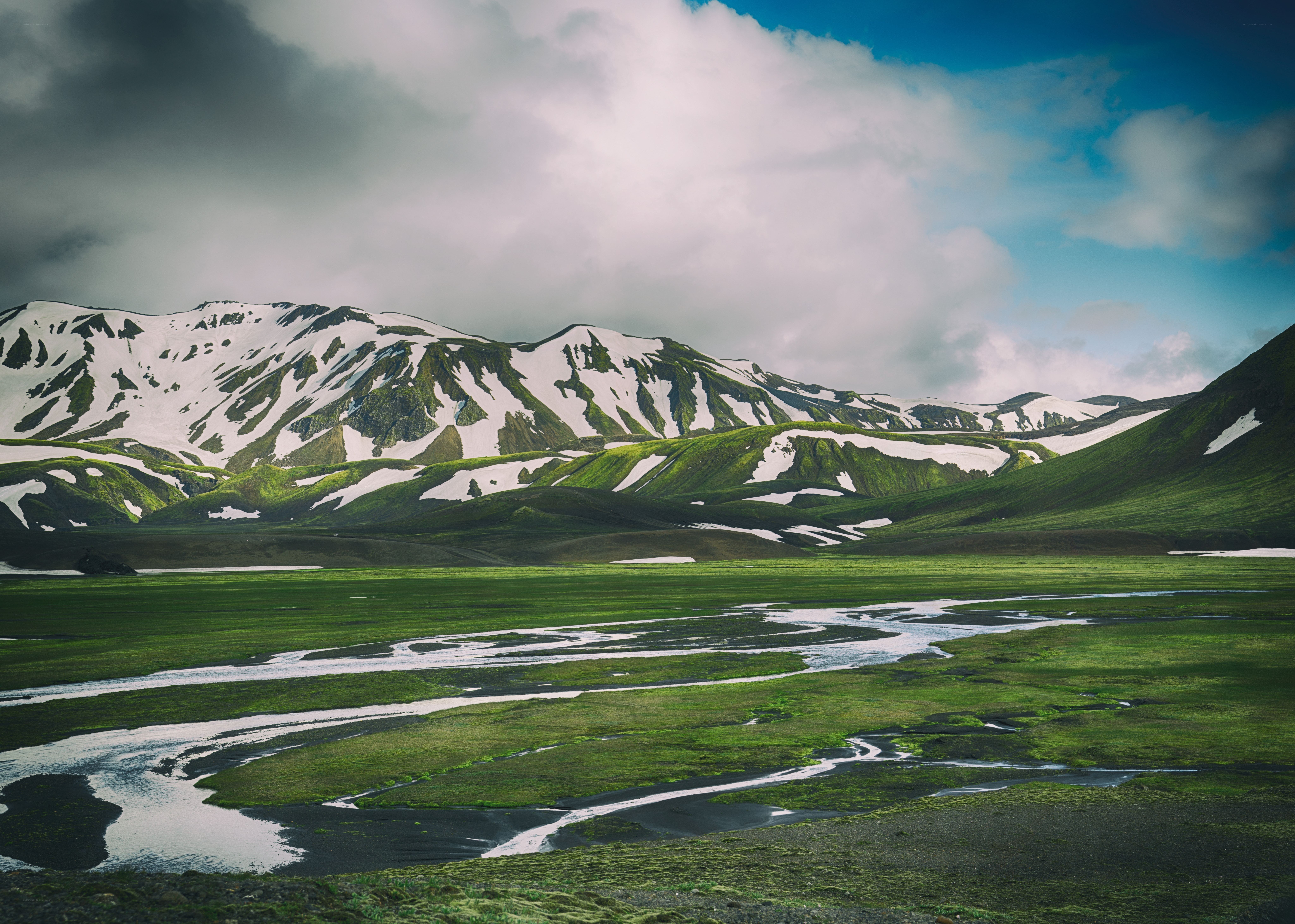 Green valley with snow-capped mountains