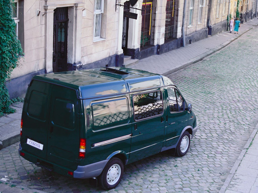 Green van on cobblestone street