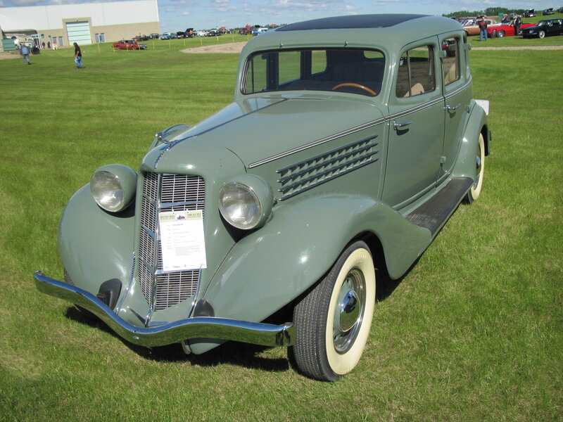 Green Vintage Car — Calm, Afternoon, Photograph, Grass Field, Other Cars, People