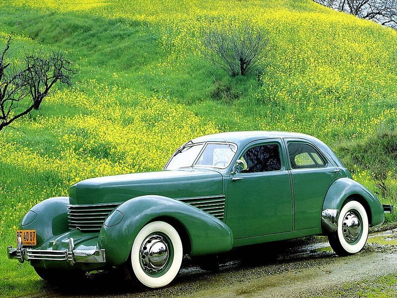 Green vintage car in flower field