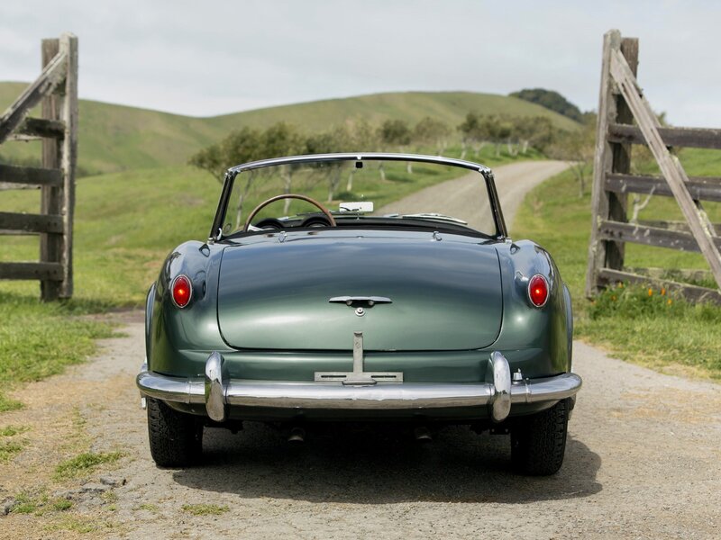 Green vintage convertible on a country road