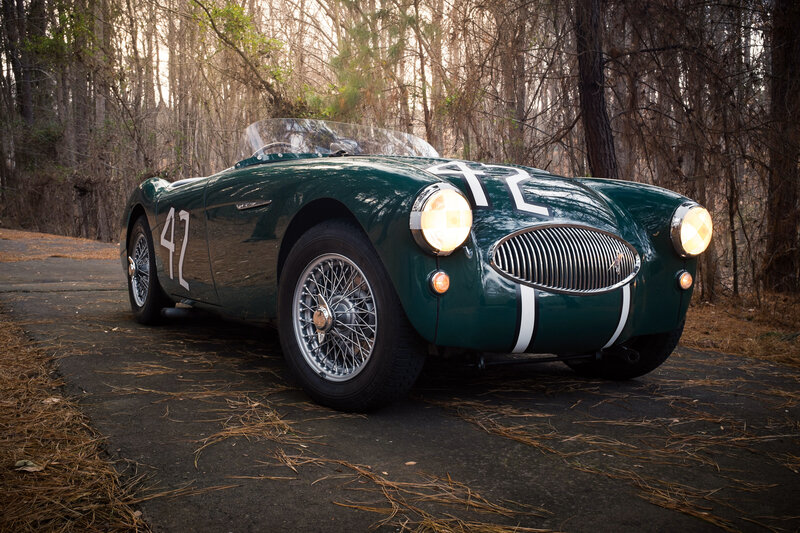 Green vintage race car in forest