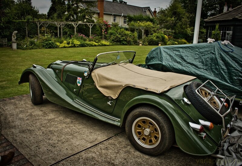 Green vintage sports car in garden