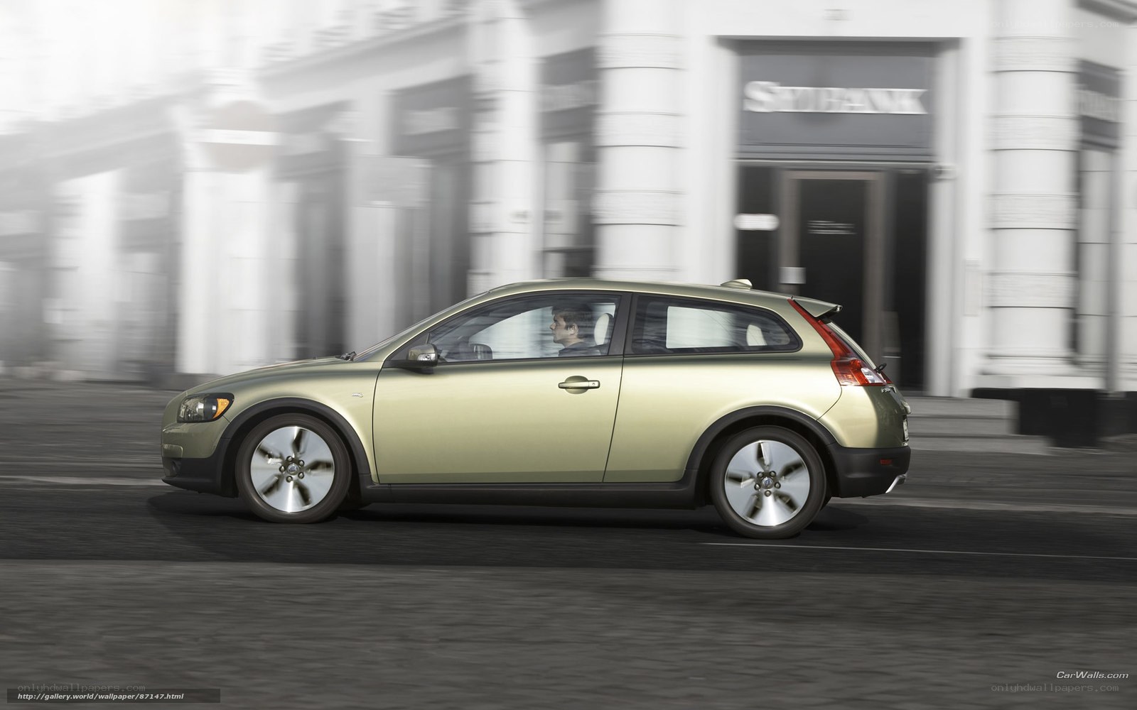 Green Volvo C30 driving on city street