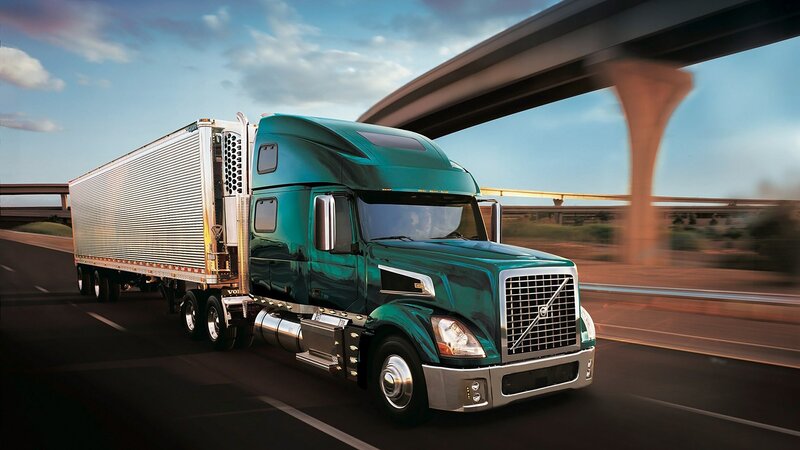 green volvo semi-truck on highway