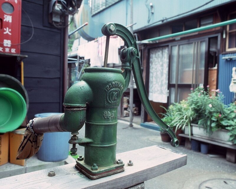 Green water pump in alley