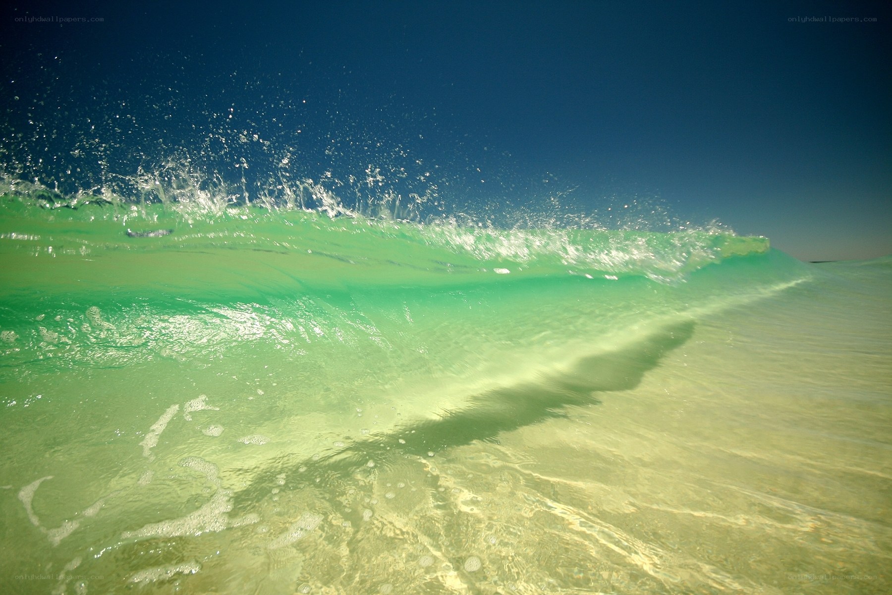 green wave breaking on shore