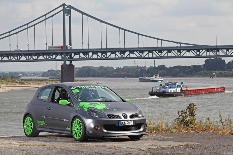 Grey car with green accents by the river