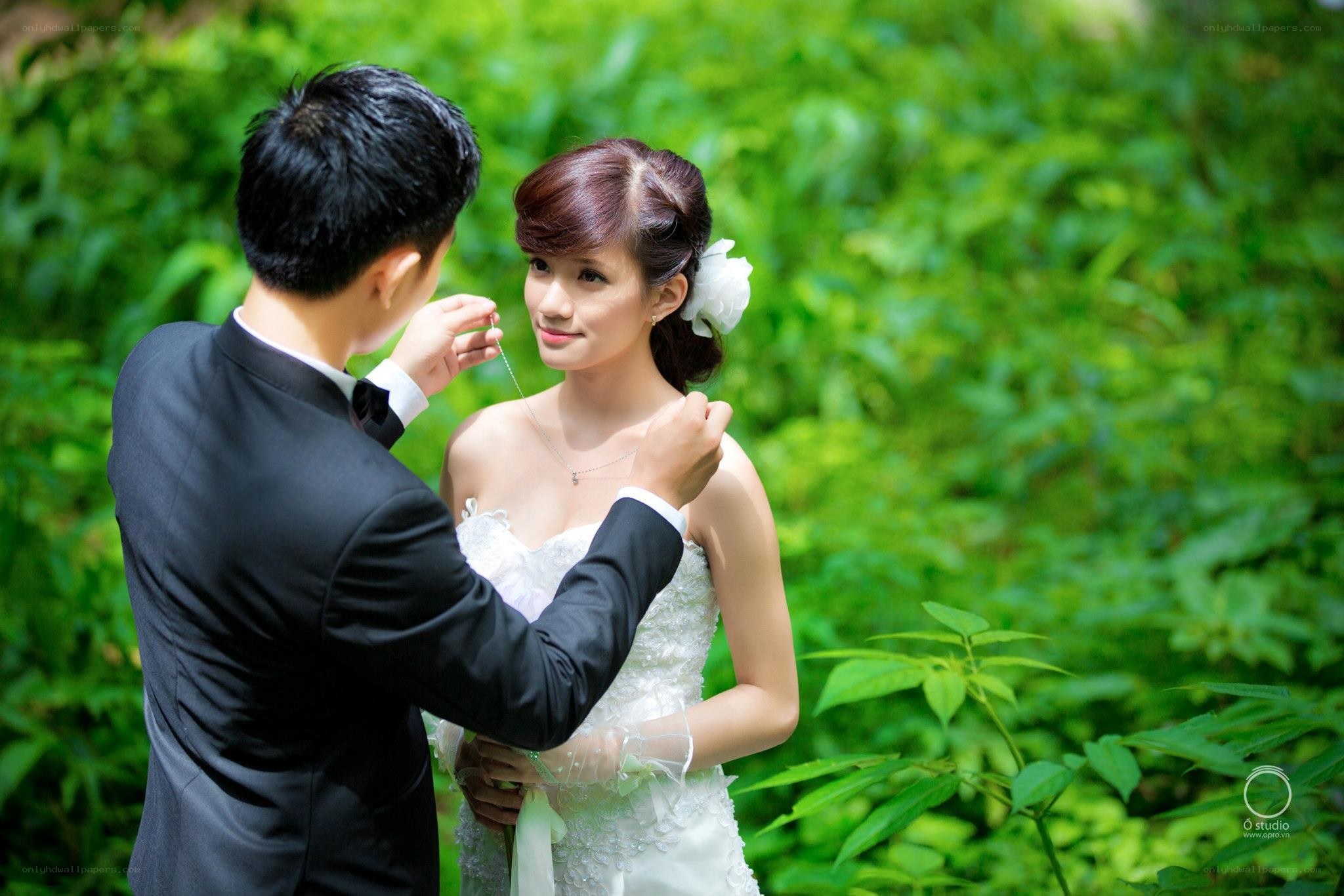groom adorns bride with necklace