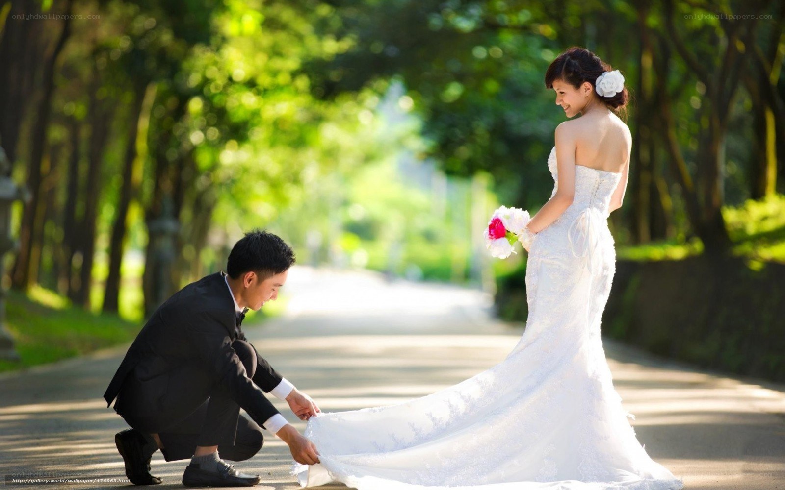 Groom helps bride with dress