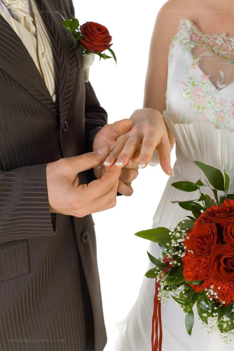 groom placing ring on bride's finger