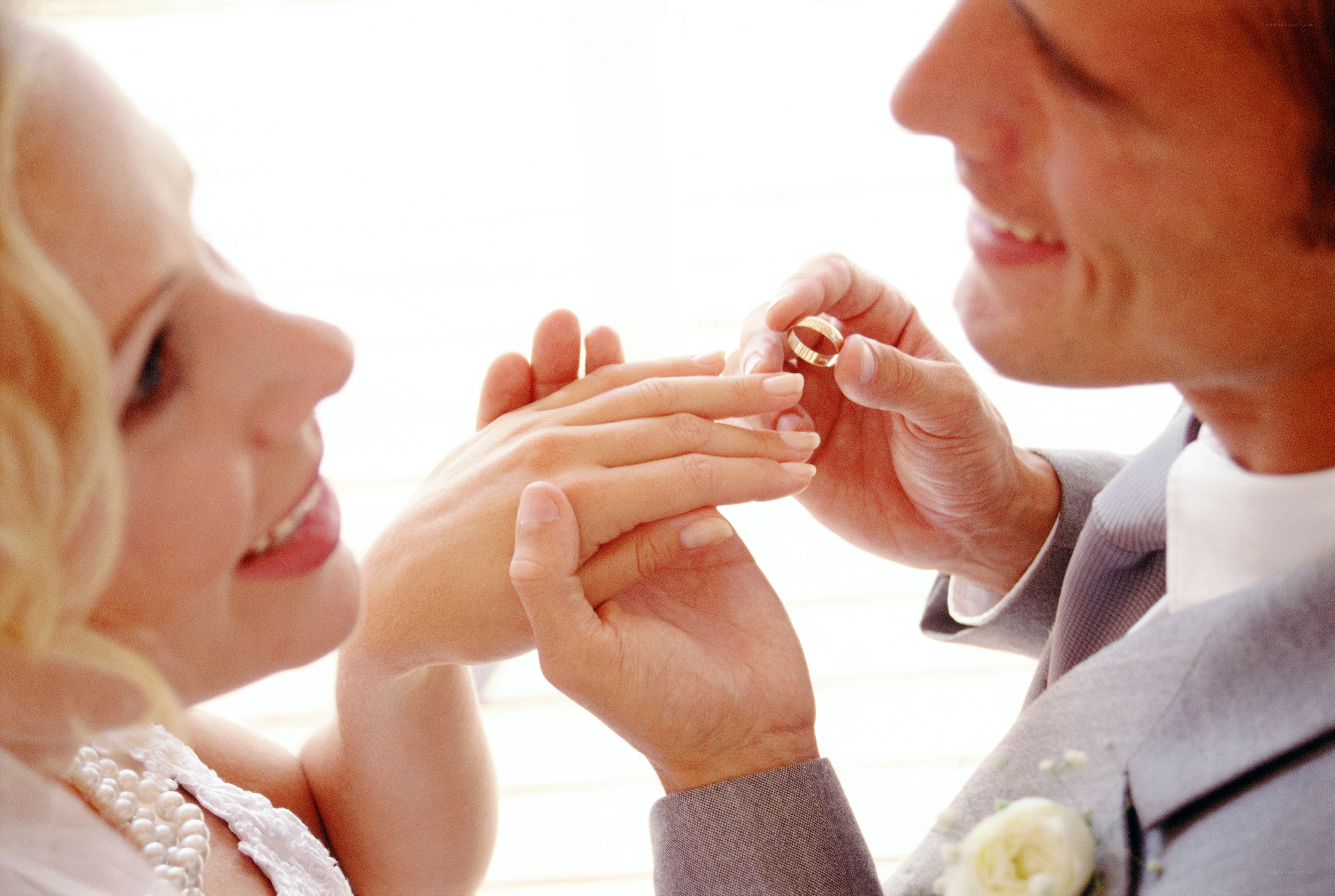 groom placing ring on bride's finger